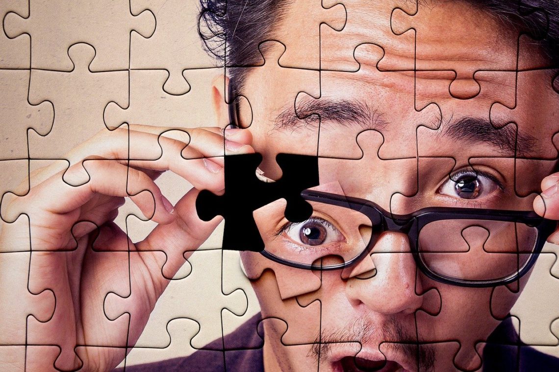 An eye is the last piece of a puzzle showing a surprised man wearing glasses.